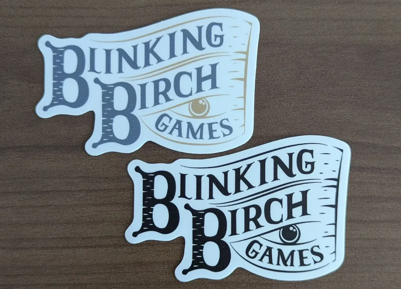 Two stickers of the logo for Blinking Birch Games. One is in color and the other is black & white.